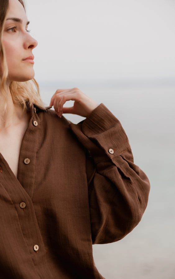 Close-up of woman wearing the brown Coconut organic cotton button-down shirt