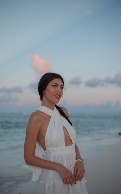 Close-up of the white Esmeralda Versatile Maxi Dress styled by the sea