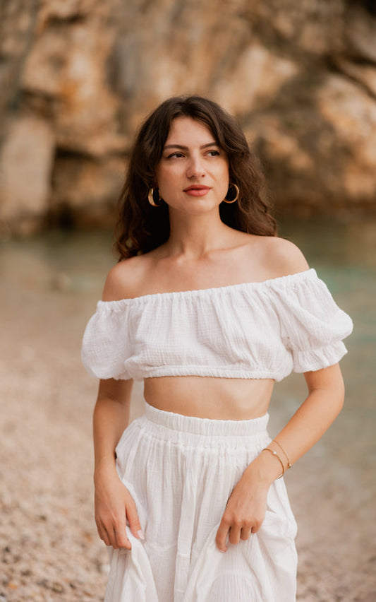 Woman wearing the white La Gitana matching set with off-shoulder crop top and maxi skirt