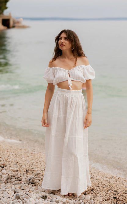 Woman wearing the white La Gitana matching set by the sea
